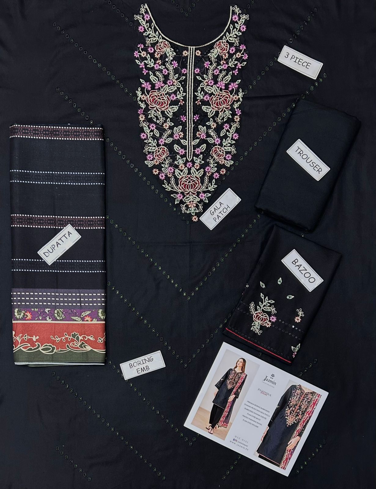 Black embroidered garment with accessories on a dark background
