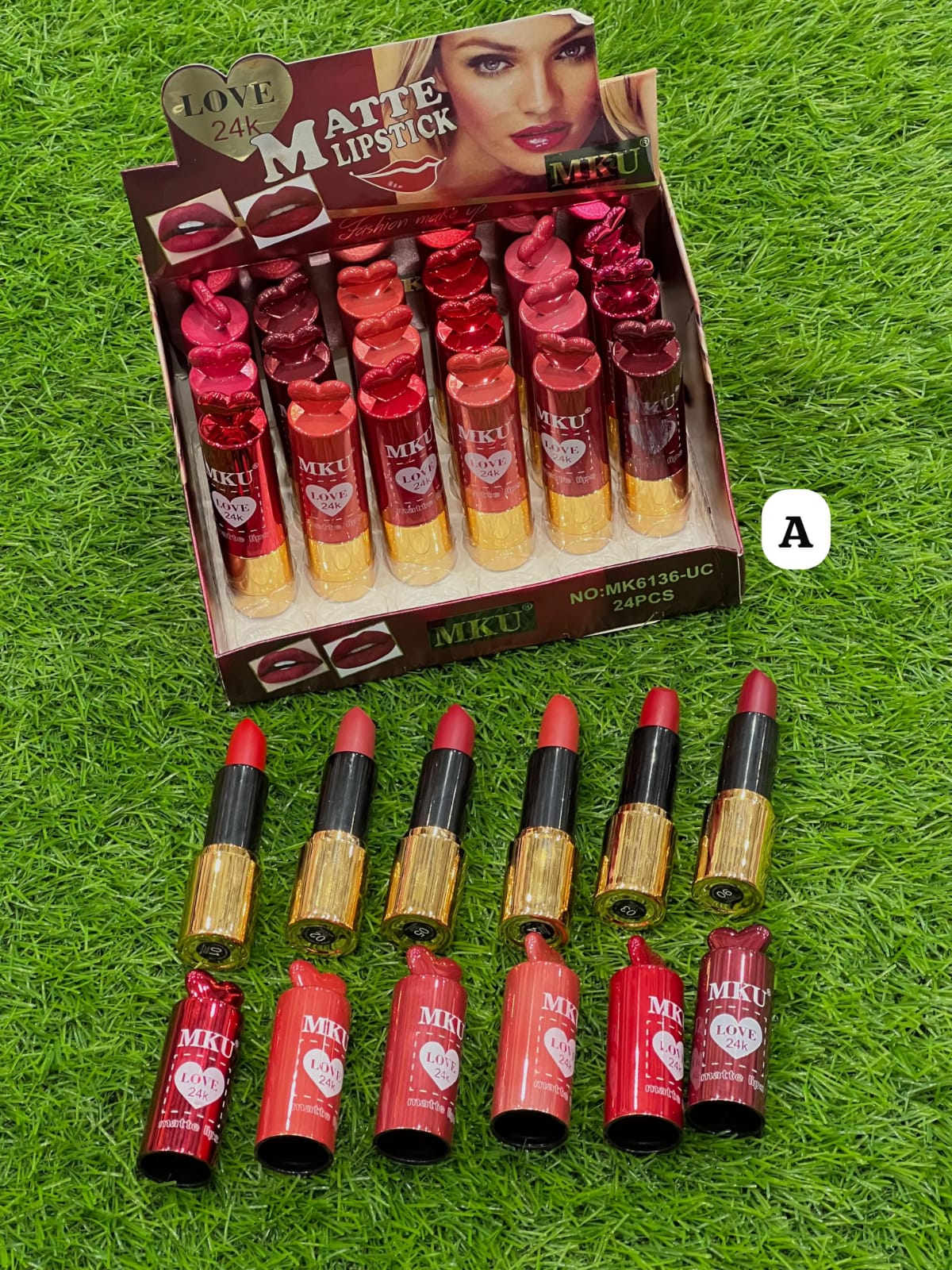 Box of MKU Matte Lipstick with lipsticks displayed on a grass background