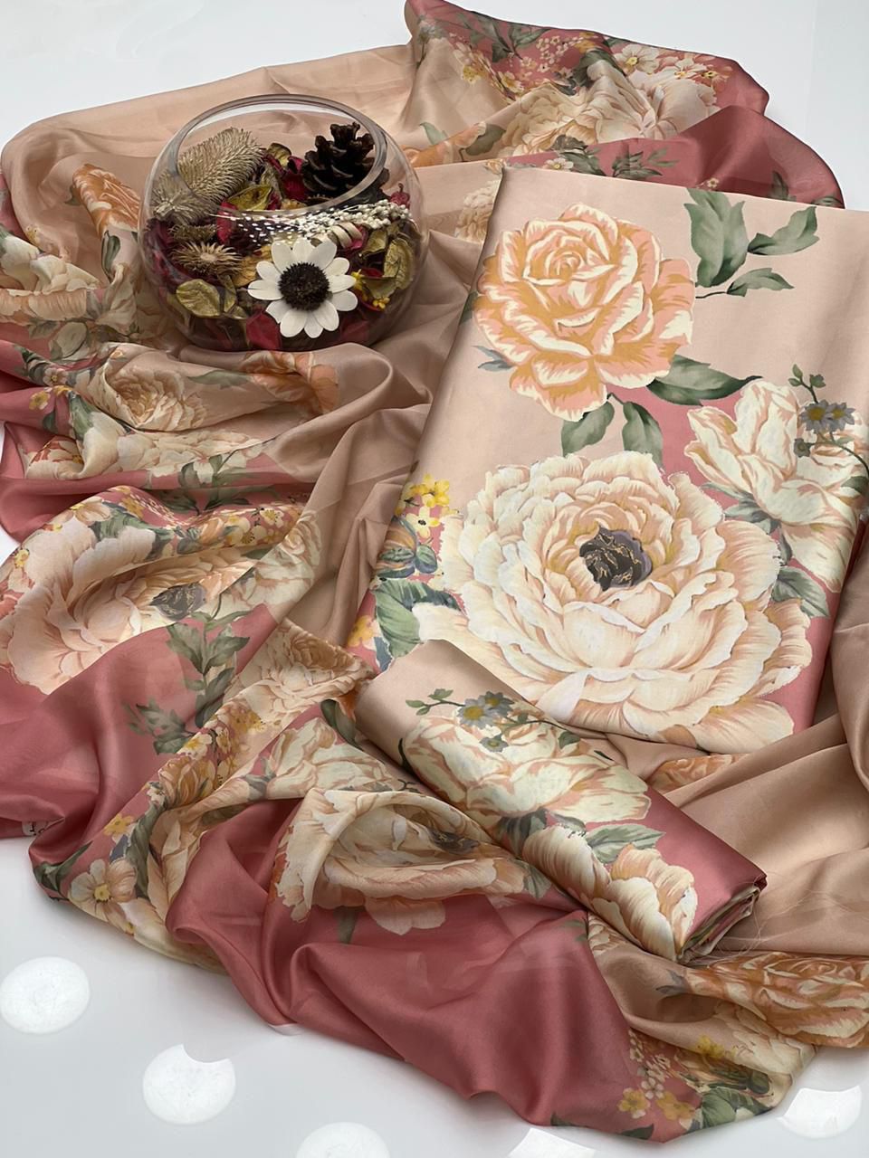 Floral-patterned fabric with a decorative glass bowl on a white background