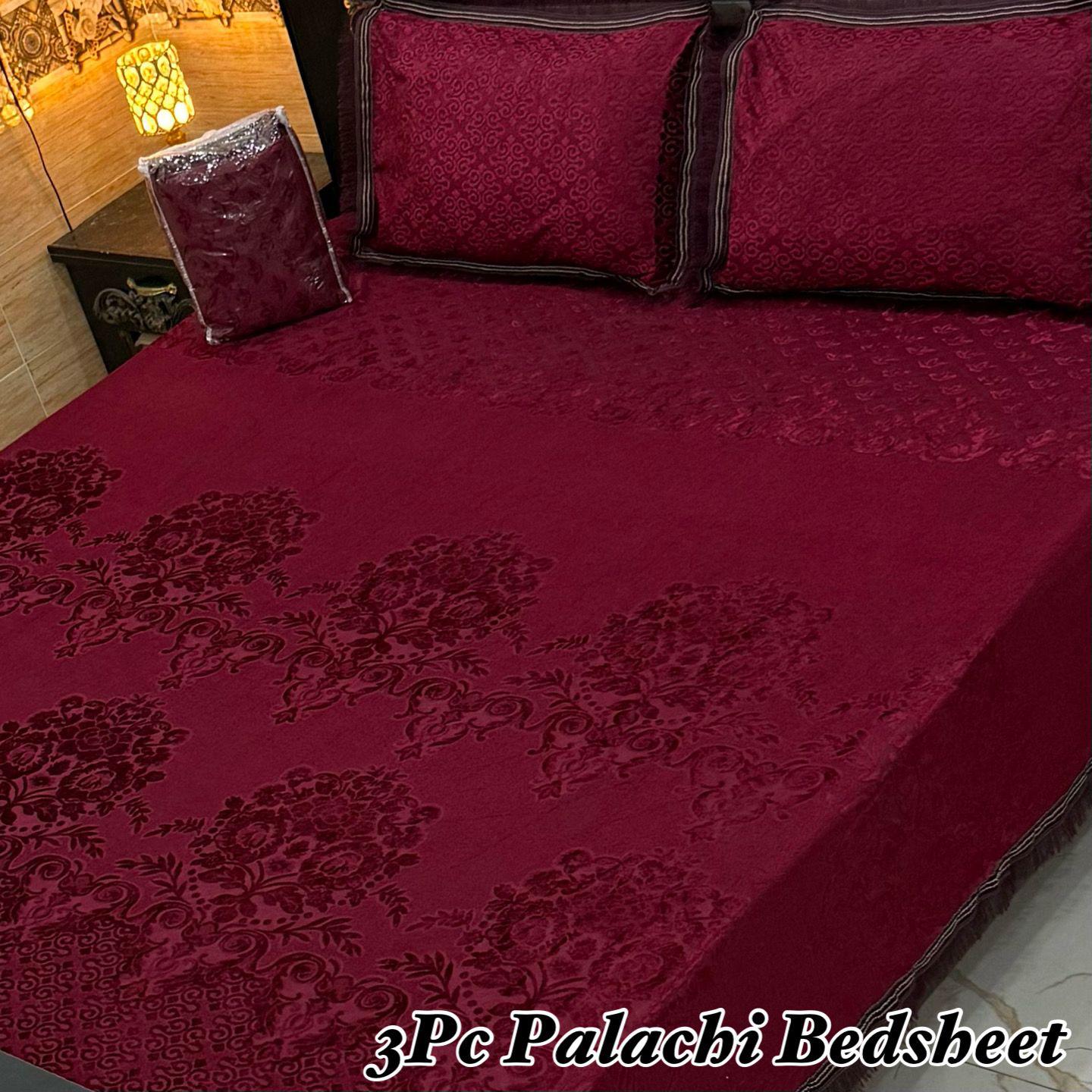 Red floral patterned bedspread on a bed with matching pillows, labeled '3Pc Palachi Bedsheet'.