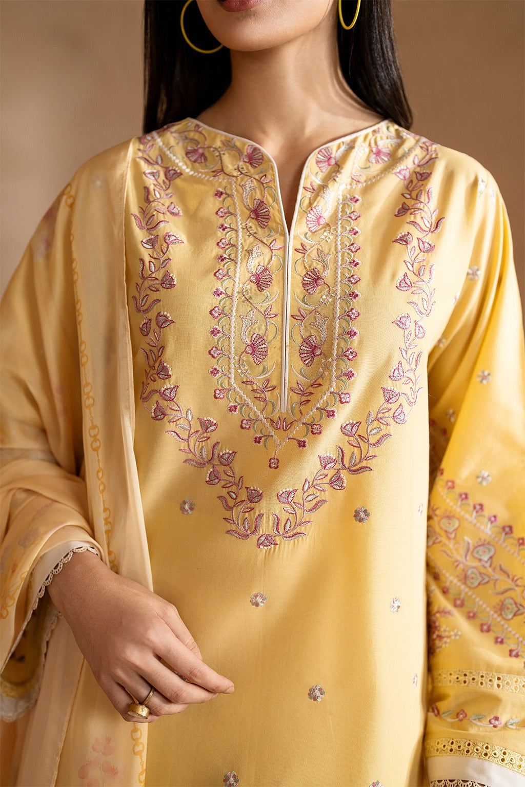 Yellow embroidered kurta worn by a person, with a neutral background