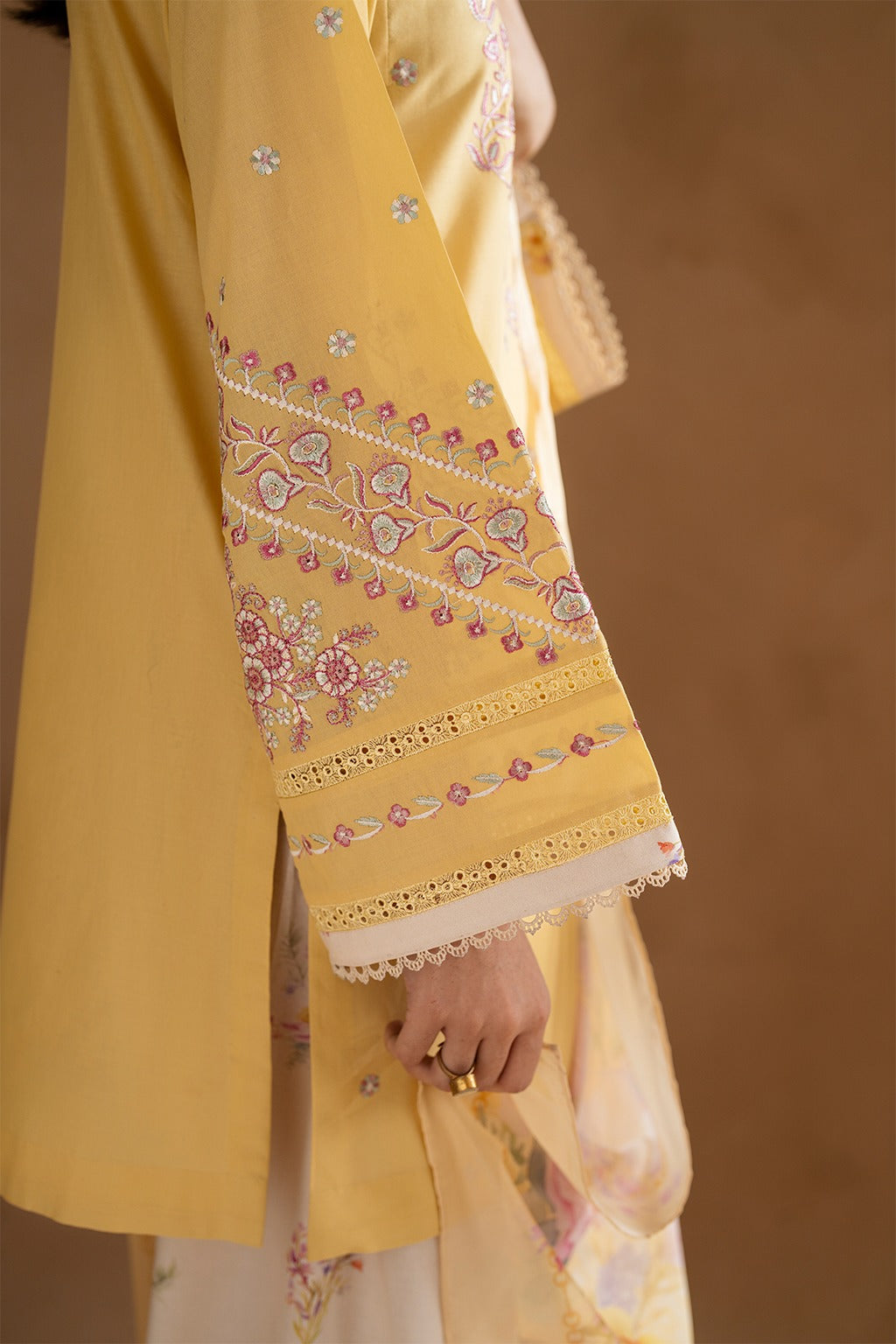 Yellow embroidered traditional outfit with a brown background
